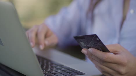 Closeup-of-female-hands-paying-online-with-credit-card-on-laptop